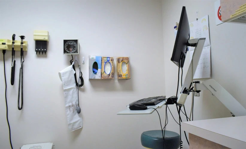 a room with a tv monitor, a telephone, and other items on the wall