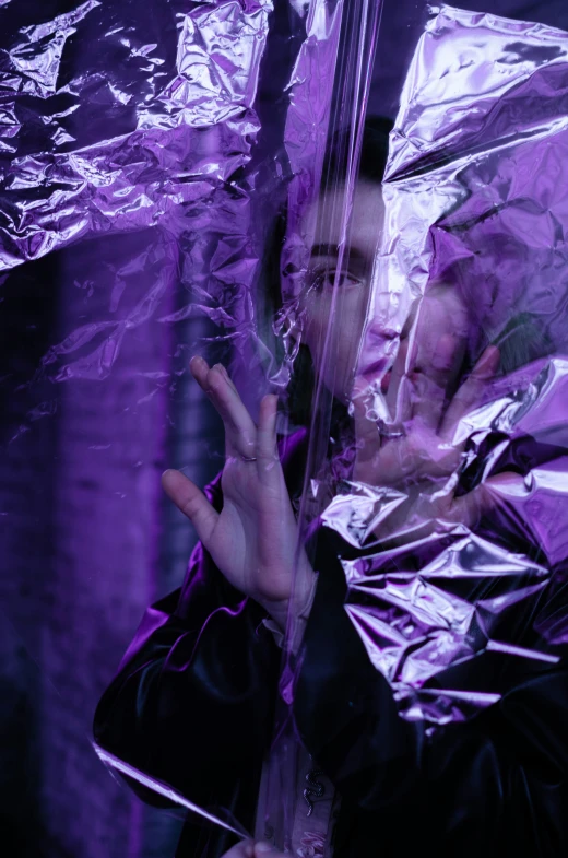 a person in purple clothes walking under plastic sheet