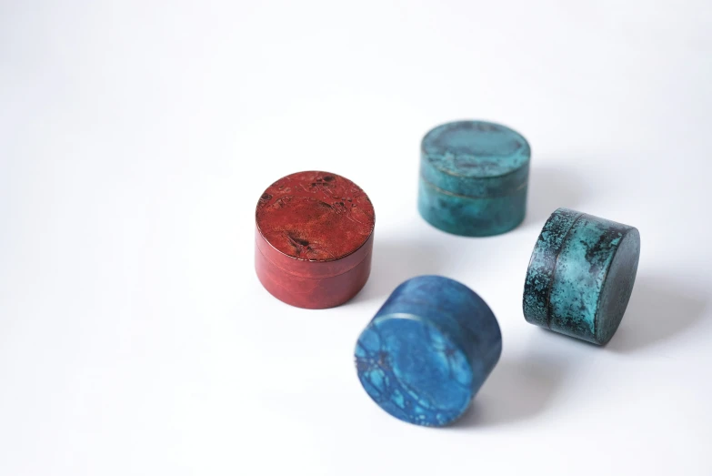 three painted wooden containers sit on top of a white surface