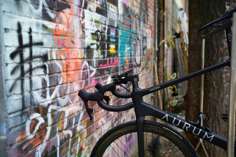 a bike that is next to some graffiti on the wall
