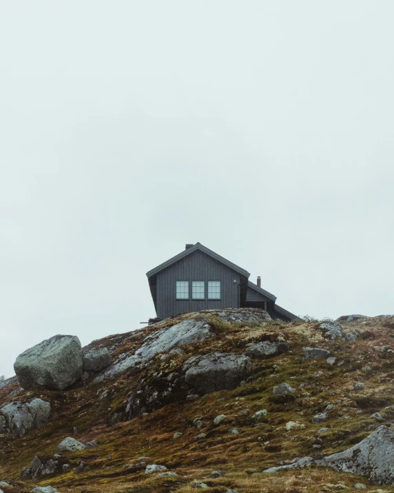 a cabin on top of a hill with two windows