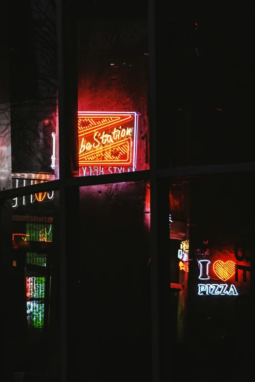 a window at night with a neon lit sign on it