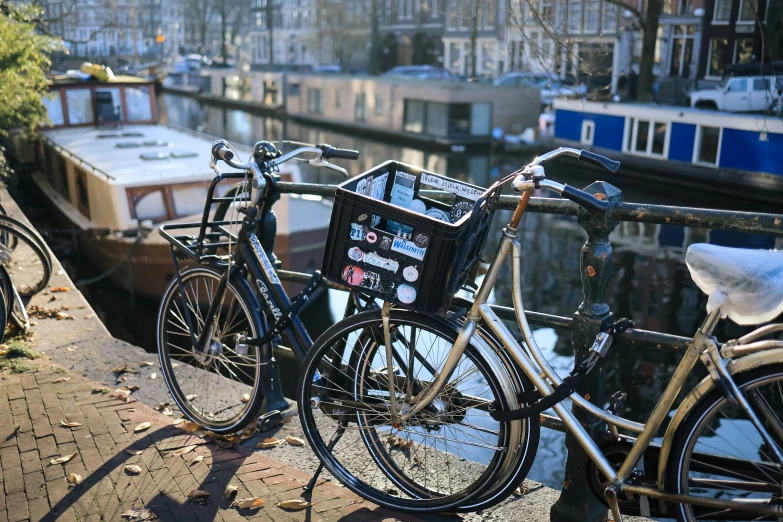 a couple of bikes parked near a canal with a houseboat in the background