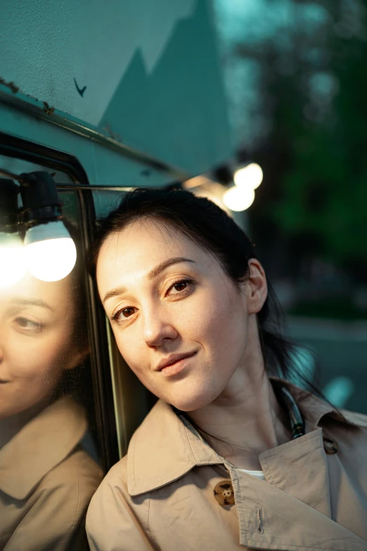 a young woman looks into the mirror and poses in the rain