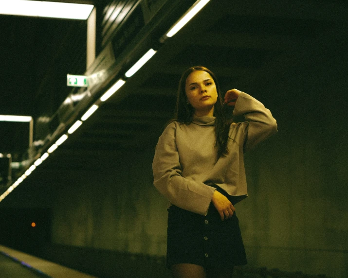 a young lady standing in an underground subway platform