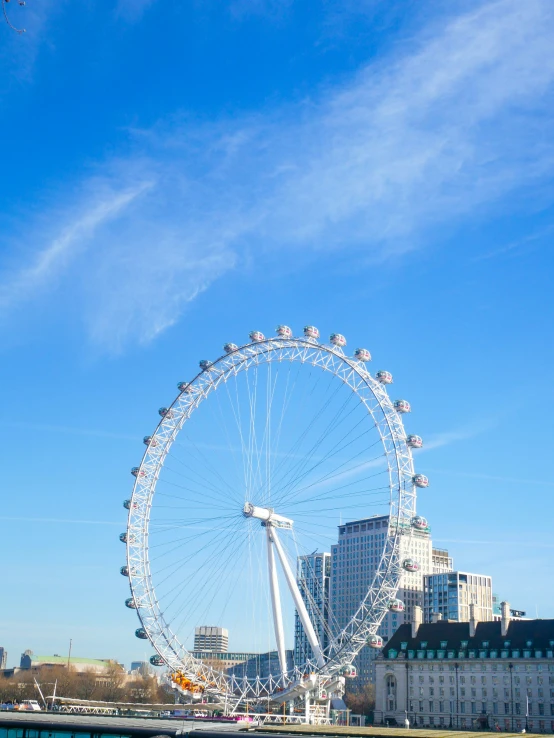 a ferris wheel near an ocean with other boats docked at the side