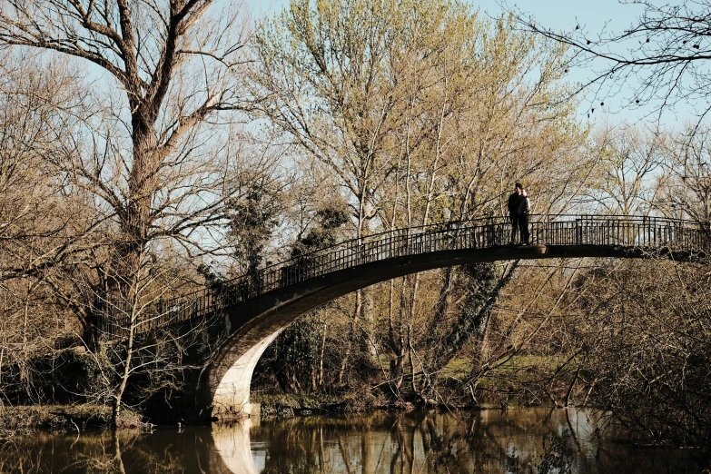 a man standing on top of a bridge over a lake