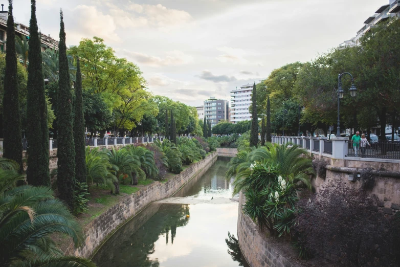 people walk near the edge of an urban waterway