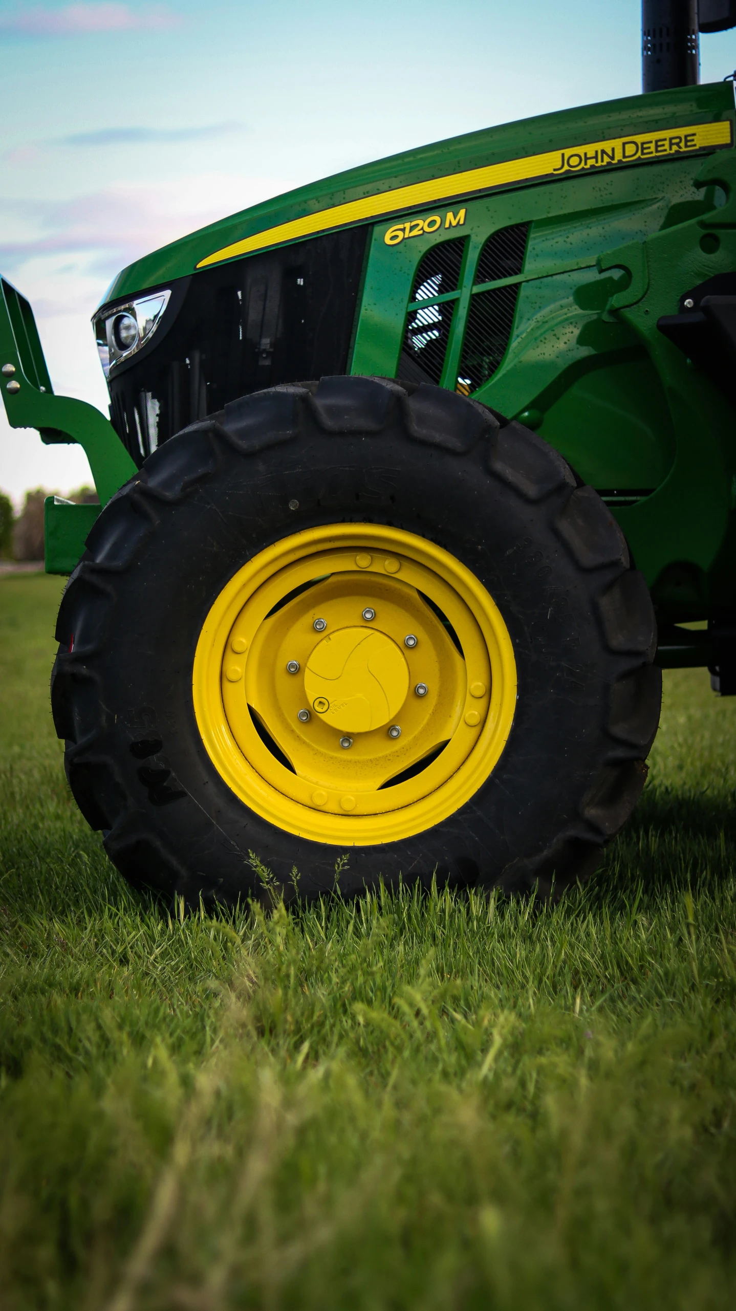 a big green tractor is in the middle of some green grass