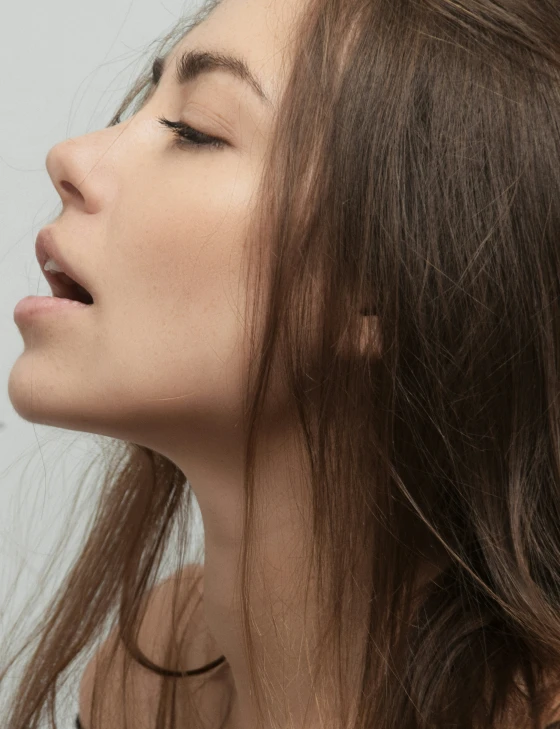 an attractive young woman looking up with eyes closed