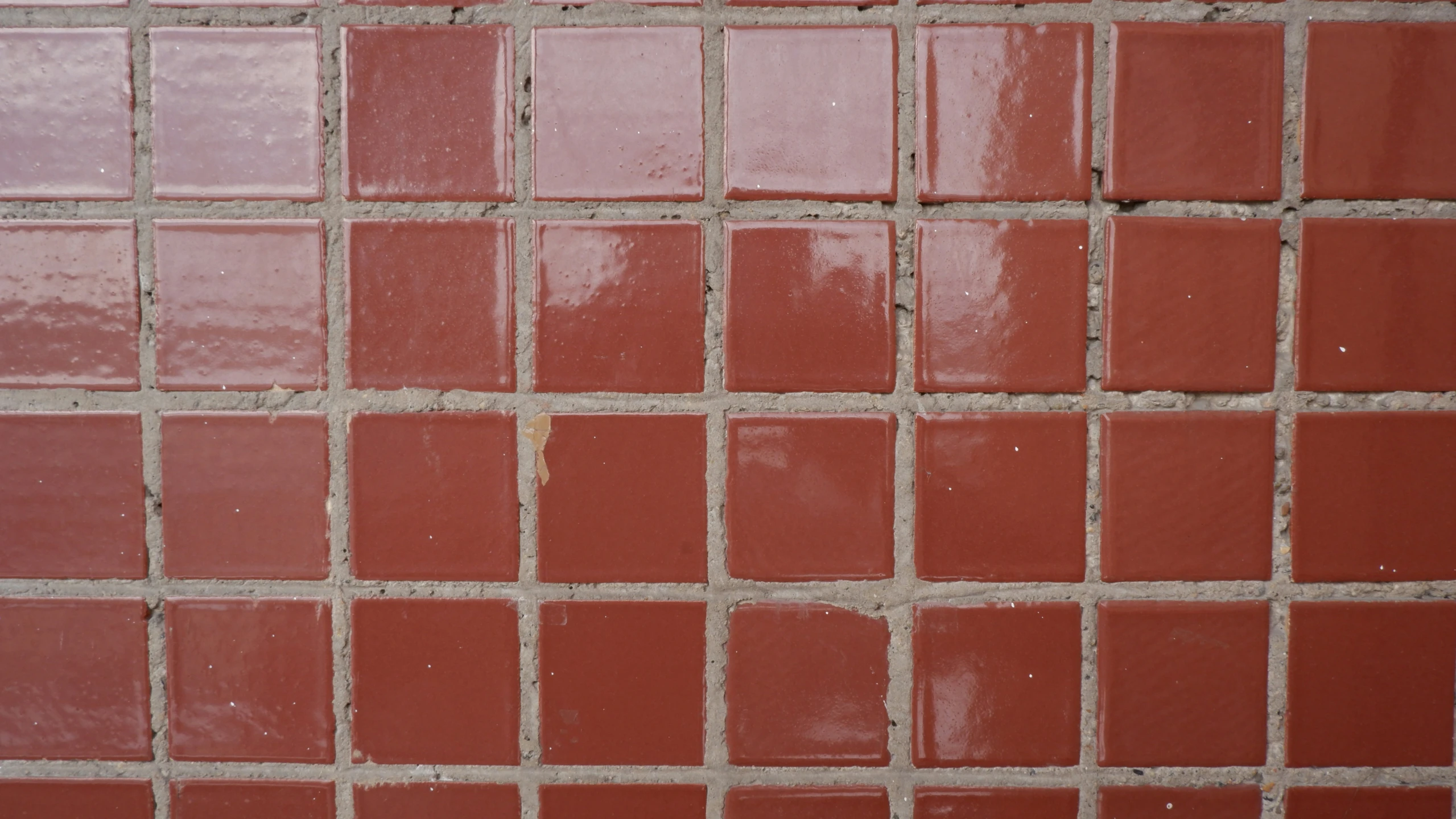 a toilet with a tiled wall in the background