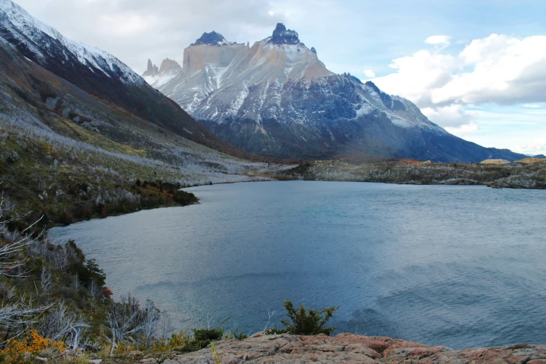 a mountain range next to a small lake