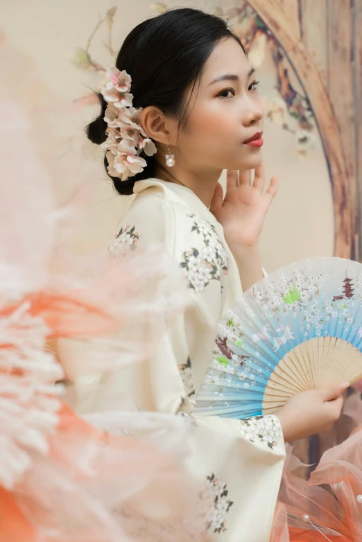 a woman with an oriental hairstyle and hand fan