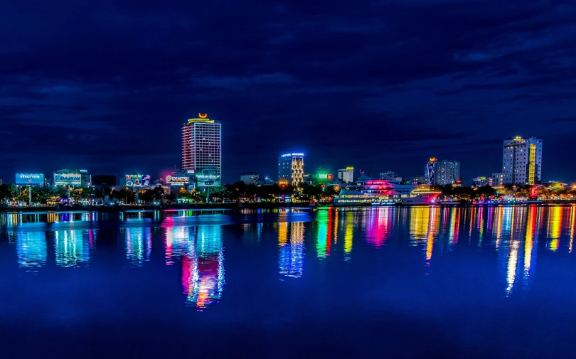 there are many lights in the water and the building is tall