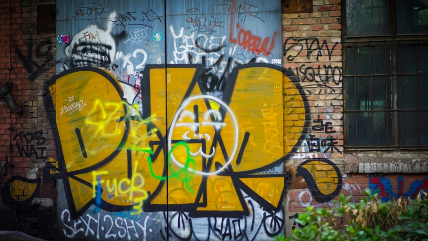 a brick building covered in grafitti, with windows and walls