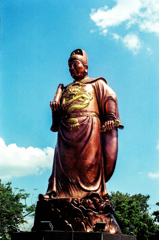 a large golden statue stands on top of a hill