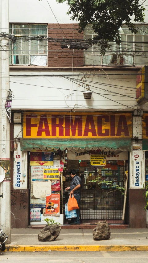 a man is standing in front of a farmacac shop