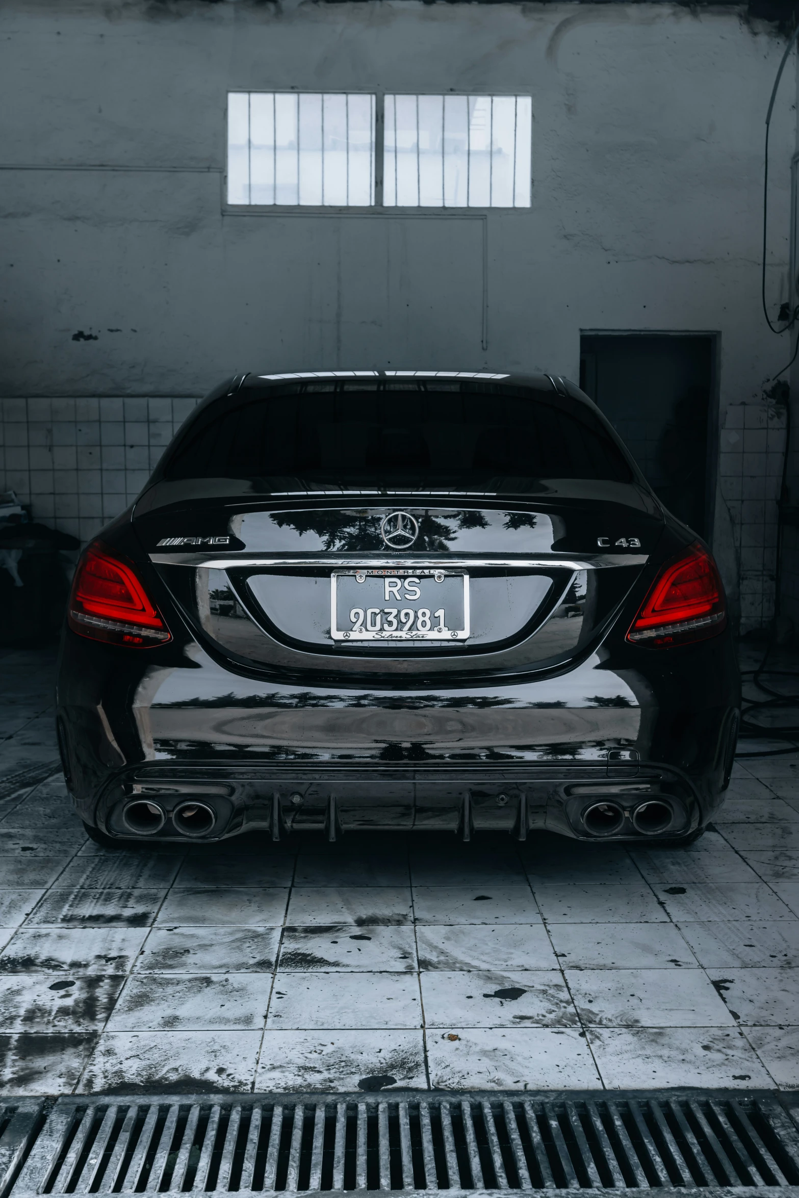 the back end of a black car parked in a garage