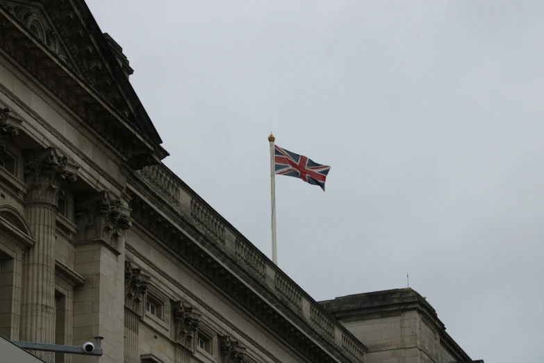 a union jacked flag flies from a tall building