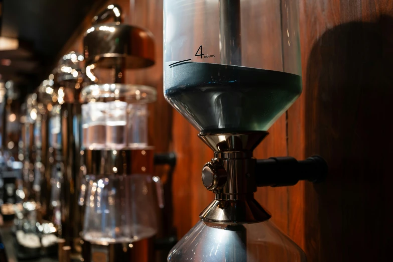 an coffee pot with a green top sitting next to other espresso machines