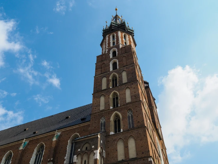 the tall clock tower stands high up against a blue sky