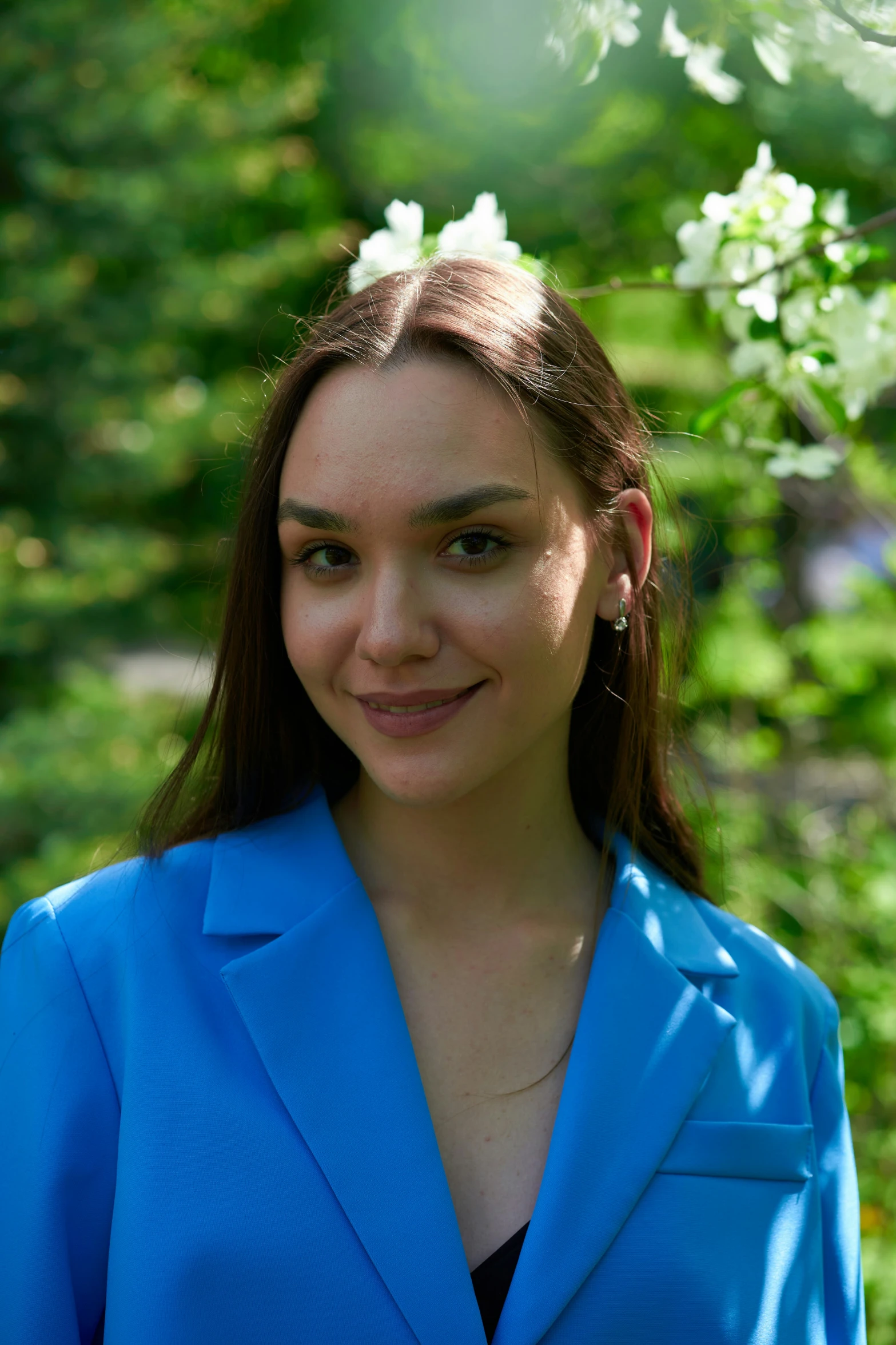 woman with blue shirt posing for camera by the grass