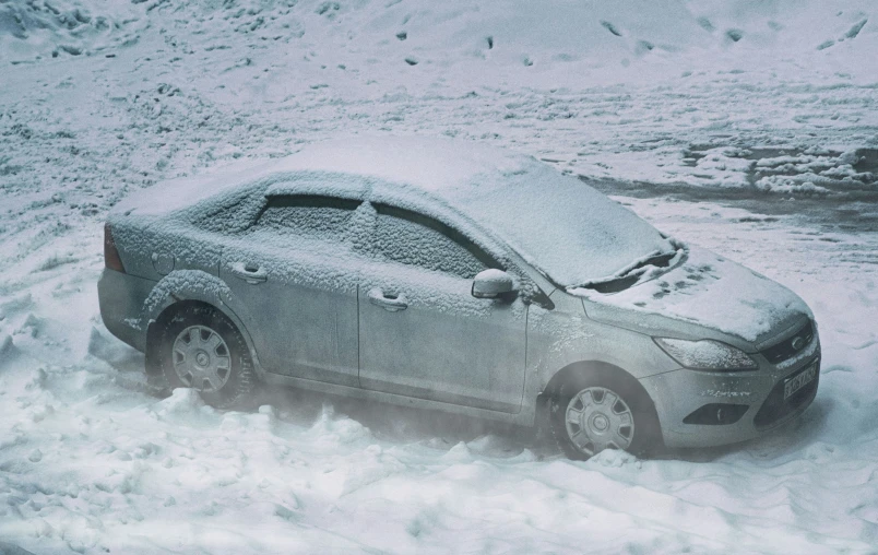 a gray car is parked on the side of the road