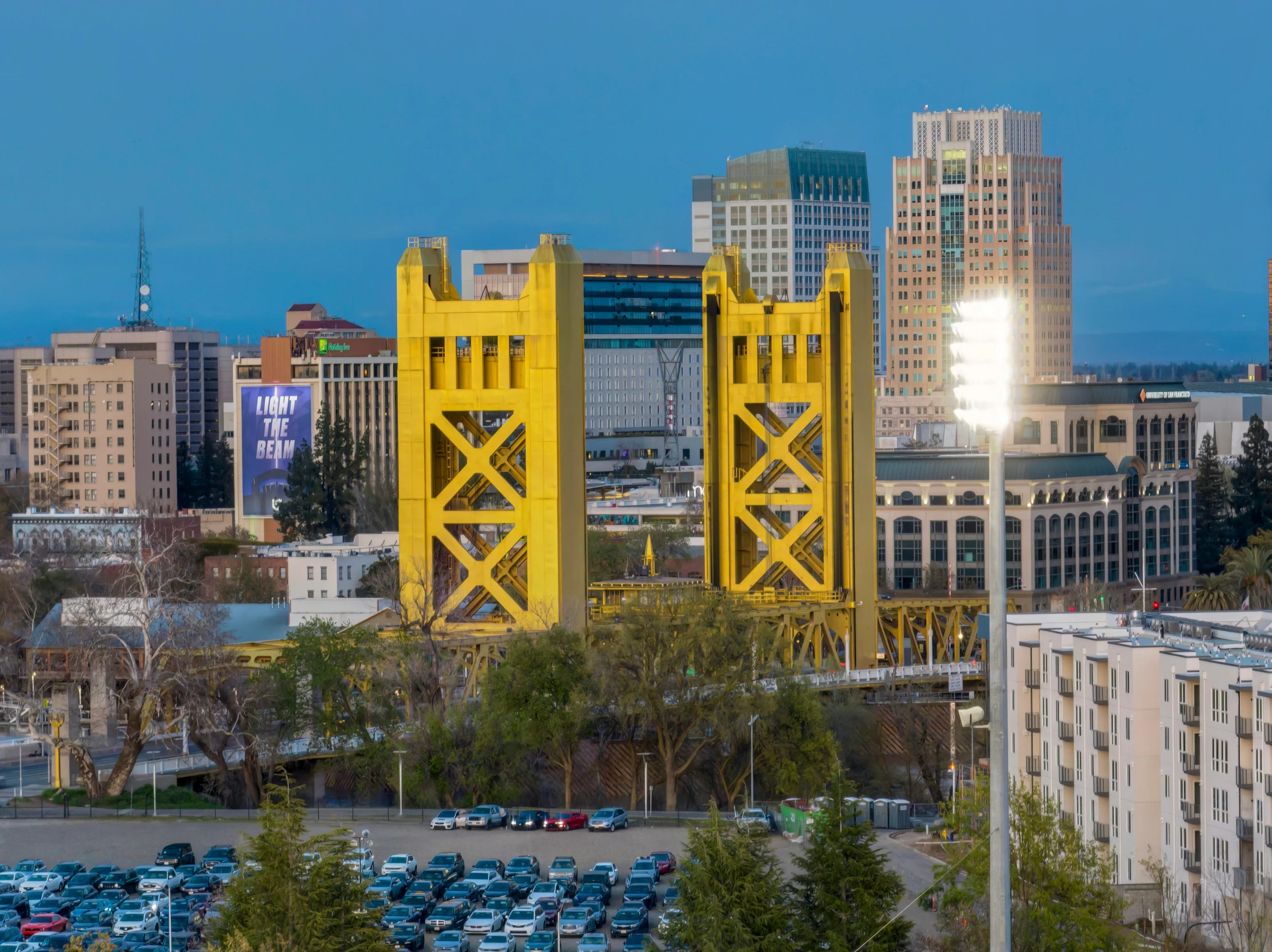 a tall yellow tower sitting above cars parked in a parking lot