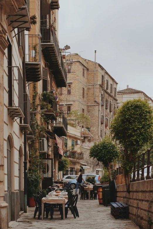 a few people sitting at tables on an alley