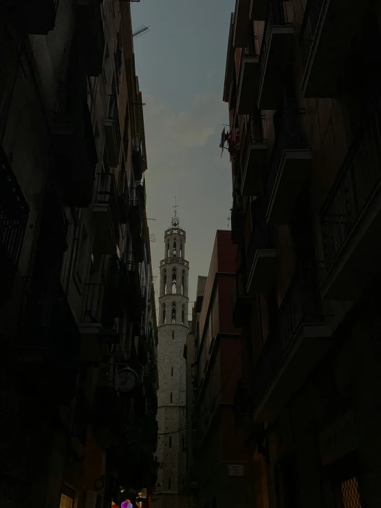 the dark streets with people walking under an old clock tower