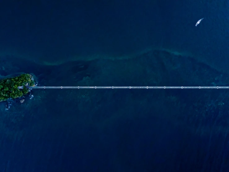 a jet flying over an island with trees in the middle