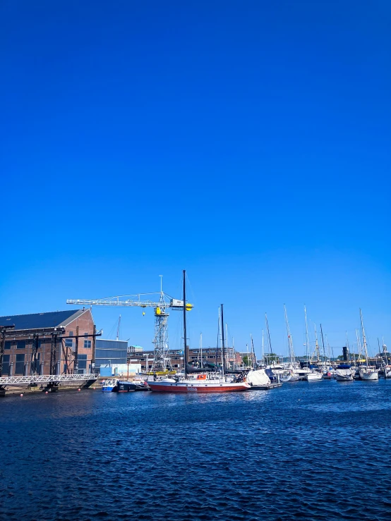 sailboats in a harbor next to a warehouse