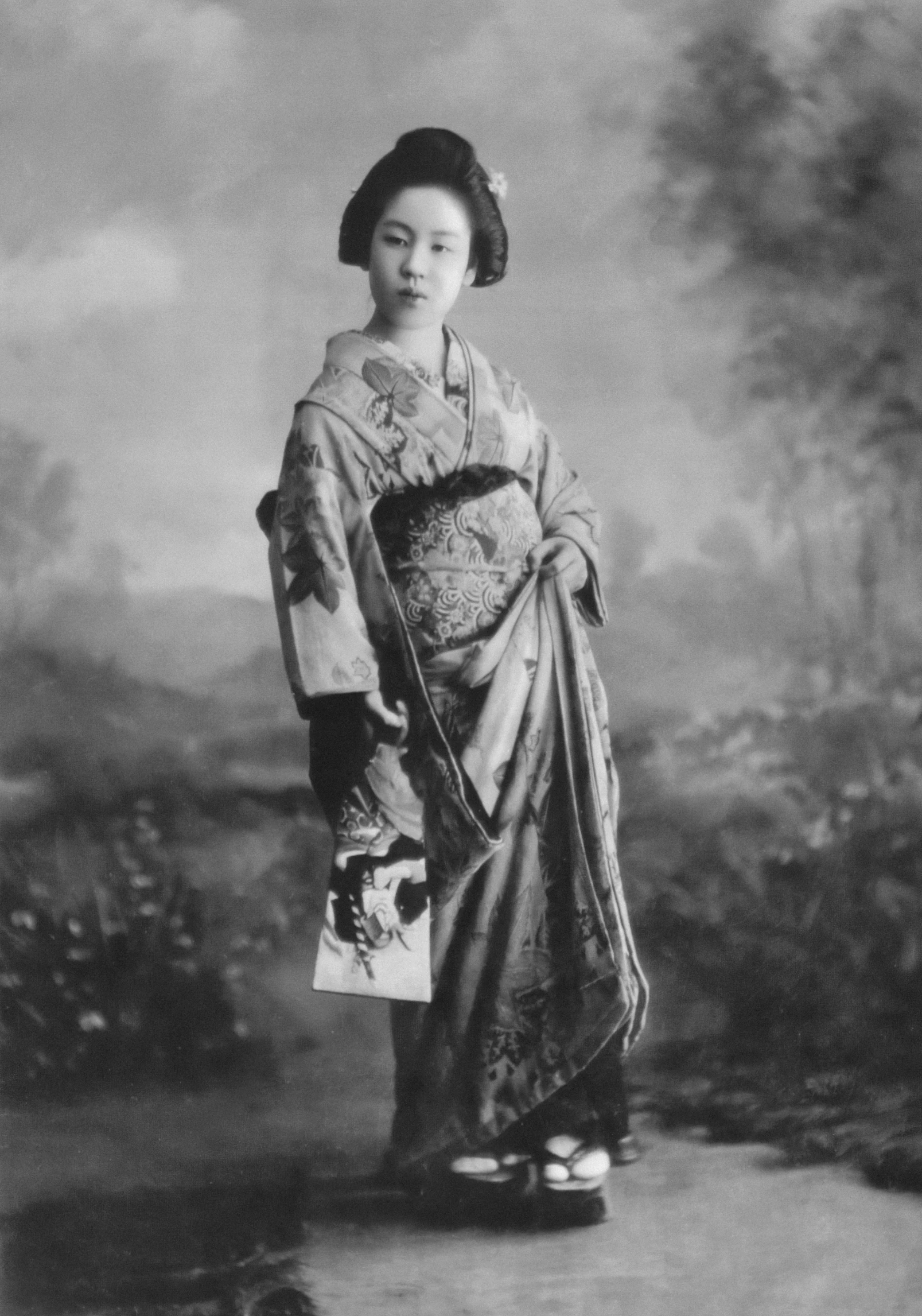 an antique japanese woman in traditional clothing poses for a pograph