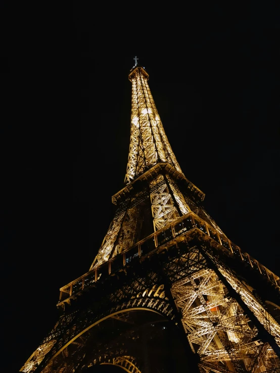 the illuminated eiffel tower at night, showing its gold color