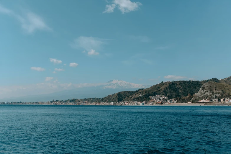 a small boat is on the ocean near a city