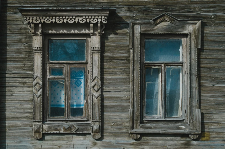 two windows with carvings on the side of the building