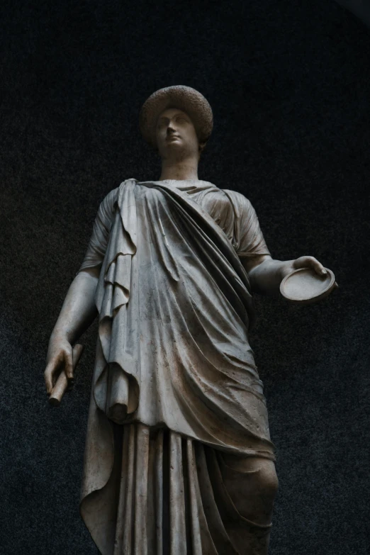 a statue of a man holding a dish with one hand