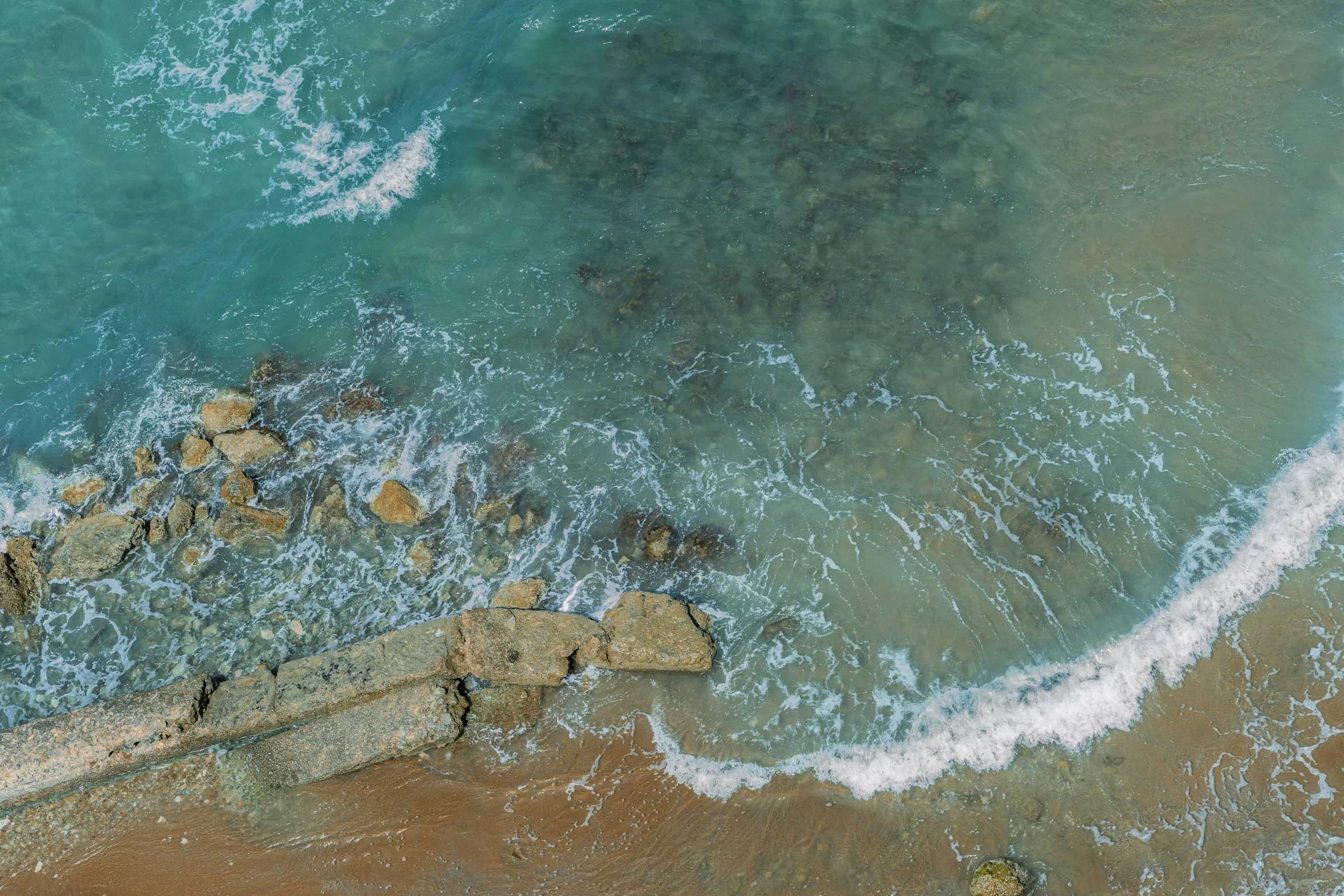 an aerial po of waves coming in on the shore