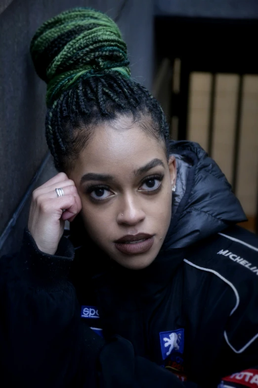 a woman in black jacket wearing green hair and a silver ring