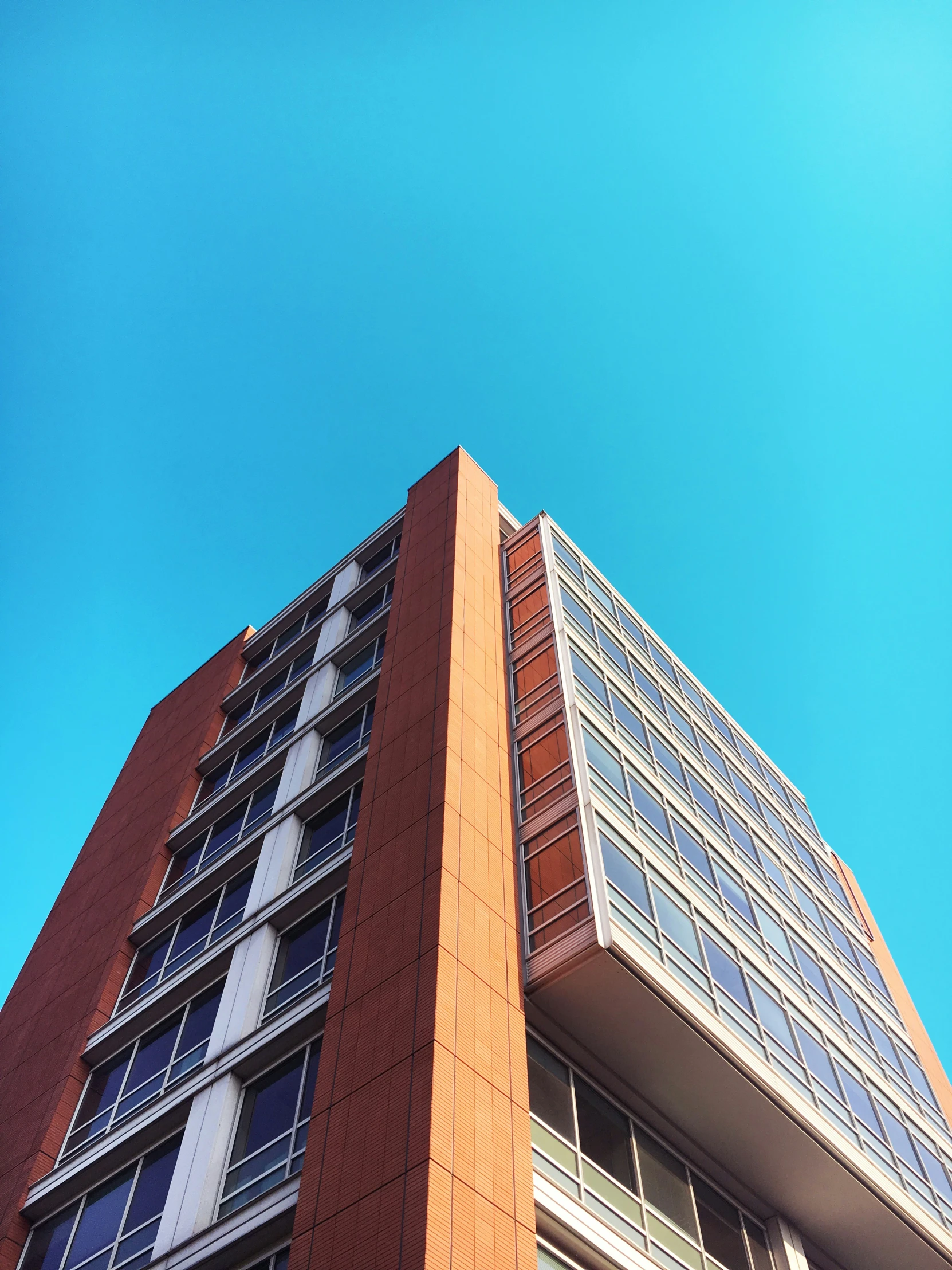 looking up at a tall building against a blue sky