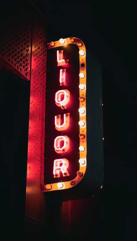 a neon sign reads liquor on the street