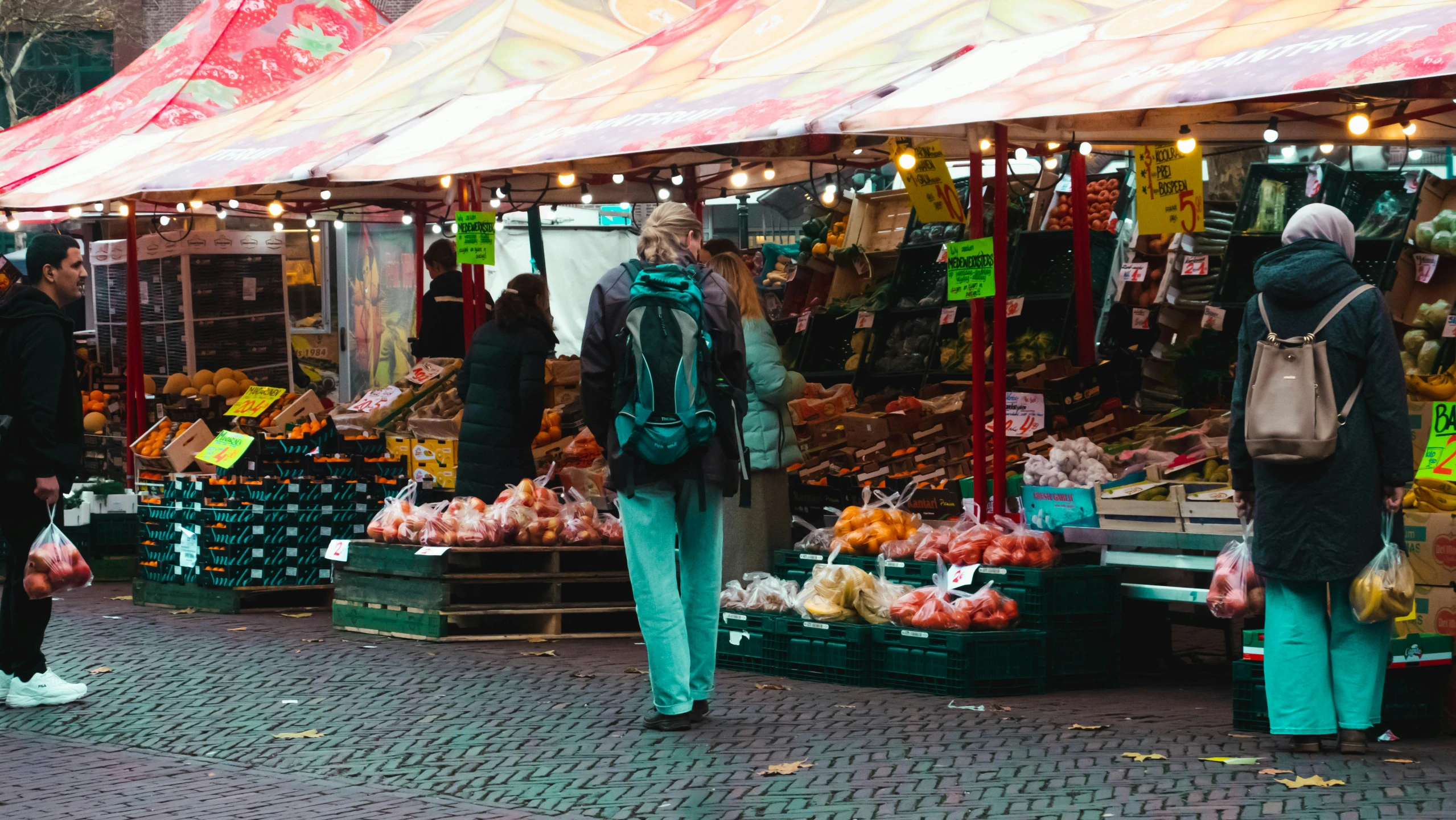 people walking around an outdoor market in the day