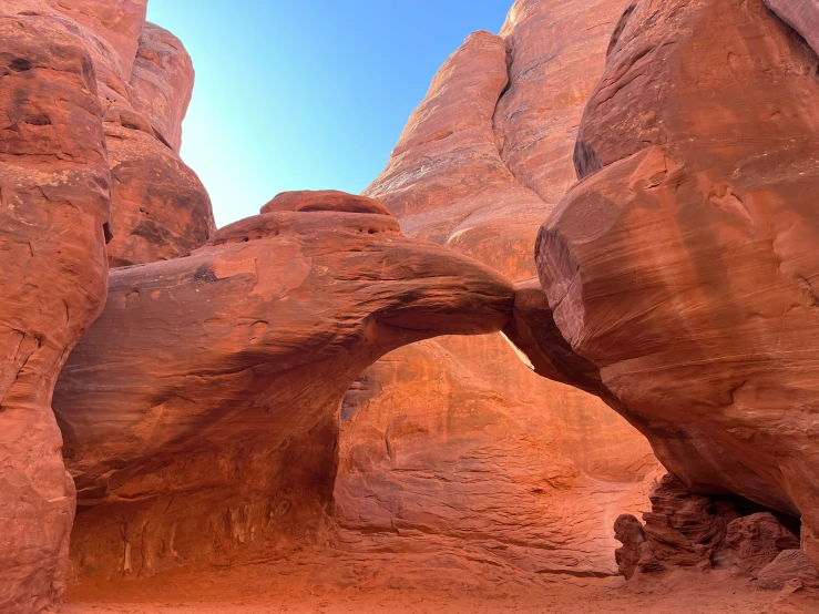 two people standing in a cave between some rocks