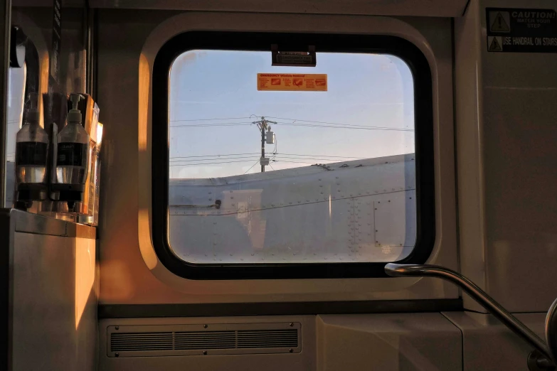 the inside view of a train car looking out on power lines