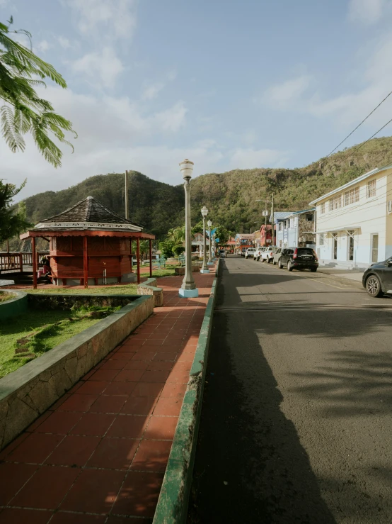 some cars and buildings in the street and hills