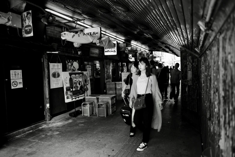 a woman walking down the sidewalk carrying a large bag