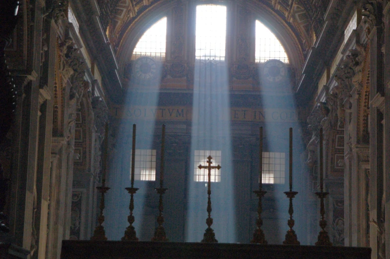 sunlight streaming through the windows in the interior of a church