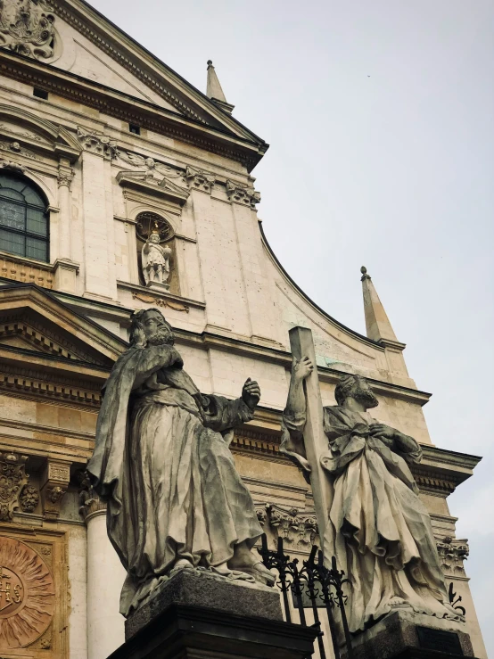 a large white cathedral with statues in front of it