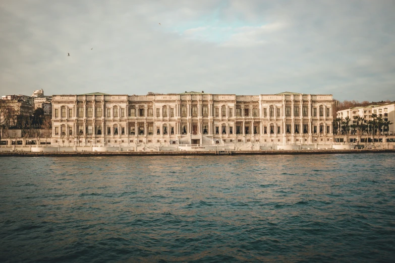 a long building sitting on the shore next to a body of water