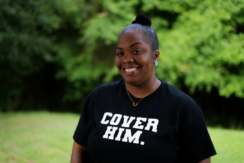 a woman wearing a black shirt is standing outside